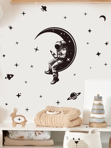 Close-up of PVC astronaut and moon wall stickers in a cozy minimalist kids room