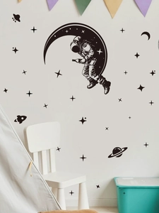 Detail view of astronaut and moon wall stickers set in a cozy kids bedroom setting