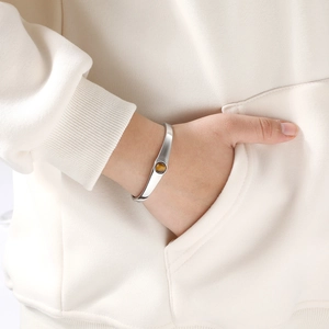 Vue détaillée du bracelet géométrique en acier doré avec pierre d'oeil de tigre