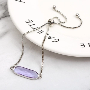 Adjustable silver chain bracelet featuring a faceted purple oval crystal stone