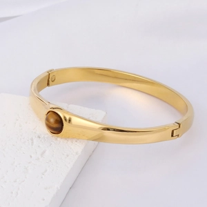 Détail macro du bracelet en acier inoxydable doré 18K avec une pierre œil de tigre ronde