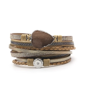Detail van een bohemian gelaagde armband met kaki vlechtwerk en hartvormige steen