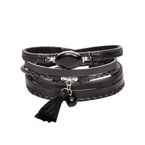 Detail view of multi-layer leather bracelet featuring a black agate stone and tassels