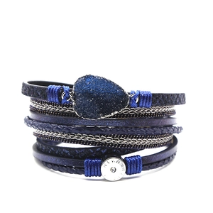 Detail van een bohemian meerlaagse blauwe wikkelarmband met hartkristal en metalen sluiting