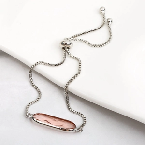 Macro shot of silver box chain bracelet with pink oval crystal and adjustable toggle