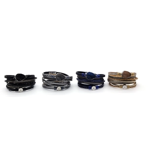 Detail van vier geweven meerlaagse lederen armbanden met edelsteen en metalen sluiting