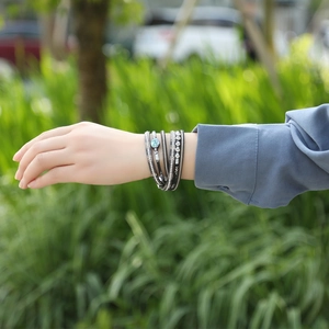 Detail of bohemian multilayer wrap bracelet with abalone shell and magnetic clasp on wrist