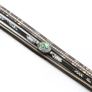Detail of bohemian multilayer bracelet with abalone shell and rhinestone inlay