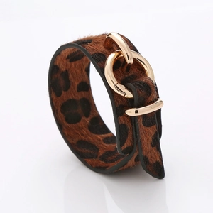 Détail du bracelet en cuir imprimé léopard avec fermoir en métal doré à double anneau
