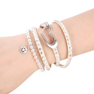 Close-up of multilayer leather heart bracelet with rhinestone inlay and smile face charm