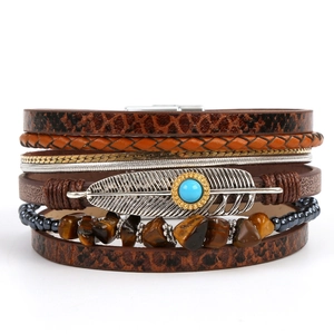 Detail of bohemian leather bracelet with silver feather and turquoise beads