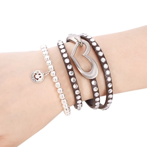 Detail of multi-layer leather heart bracelet and beaded charm bracelet on wrist