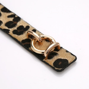 Gros plan détaillé du bracelet léopard en cuir de poulain avec boucle dorée polie brillante