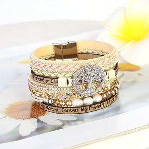 Close-up of tree of life charm on multilayer leather bracelet with magnetic clasp
