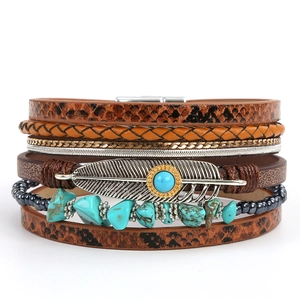 Detail view of multi-layer boho leather bracelet with turquoise and metal feather charm