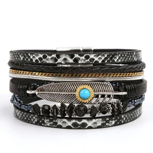 Detail view of bohemian leather bracelet with silver feather and turquoise stone