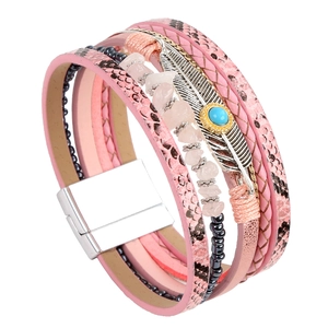 Close-up of pink multi-layer leather bracelet with silver feather and turquoise charm