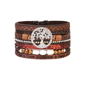 Macro detail of multi-layer braided leather bracelet with Tree of Life crystal charm