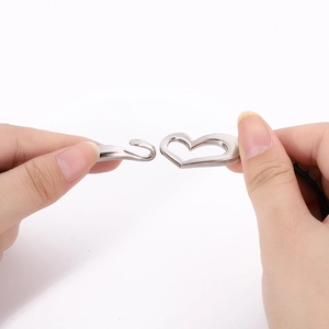 Close-up of polished silver heart clasp and S-hook connector for leather bracelet