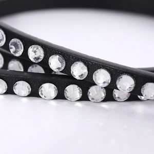 Close-up of sparkling crystals embedded in a black leather bracelet with elegant finish
