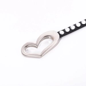 Detail of black leather bracelet with crystal inlay and silver heart-shaped metal clasp