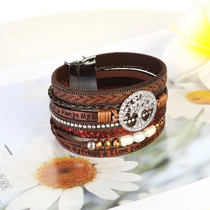 Detailed view of bohemian multilayer bracelet with Tree of Life charm and engraved leather