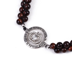 Macro view of silver apple pendant with cubic zirconia and tiger eye stone beads