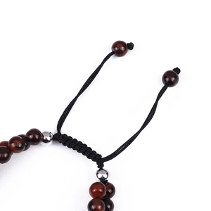 Detailed view of adjustable black braided cord and red tiger eye beads on the bracelet