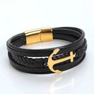 Vista detallada de pulsera de cuero negro trenzado con ancla dorada y cierre magnético