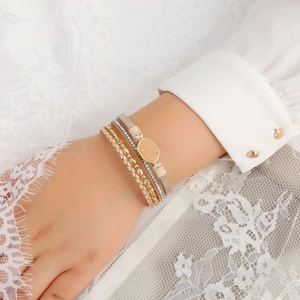 Detail of bohemian layered bracelet with gold beads, crystal bands and oval gemstone