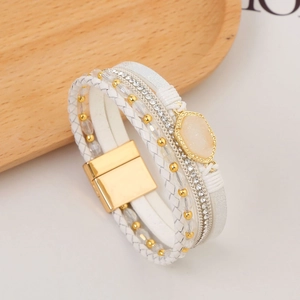 Macro detail of multi-layer leather bracelet with sparkling crystals and a gold stone center