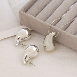 Conjunto de collar y pendientes de gota en plata pulida en bandeja de terciopelo gris