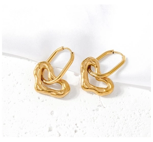 Dettaglio di orecchini a cuore in oro con ganci a U e pendenti dalla texture ondulata