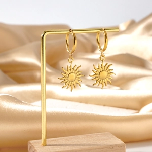 Golden sun charm hoop earrings on a display stand with a luxurious satin background