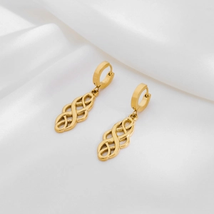 Detailed view of gold twisted knot earrings on white silk fabric with soft shadows