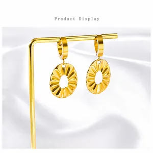 Detailed macro view of gold plated stainless steel ruffled leaf earrings on white silk background
