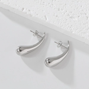 Détail macro de boucles d'oreilles goutte argentées avec fini poli et fermoir à tige