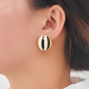 Retro-Rundohrstecker mit Emaille in Schwarz, Weiß und Gold am Ohr eines Modells
