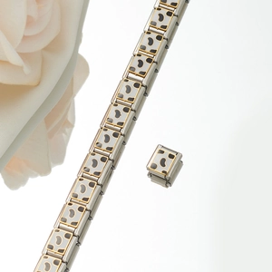 Macro shot of silver stainless steel charm bracelet links with golden leopard print patterns