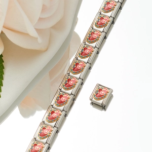 Detail of Italian charm bracelet link with red enamel heart and gold accents on white