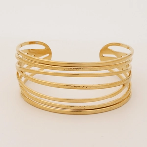 Macro shot of gold wide open cuff bracelet with parallel hammered metal bars and cut-out detail
