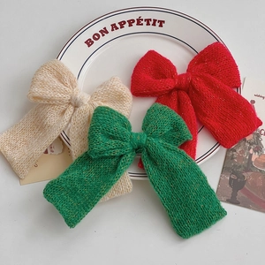 Detailed macro view of handmade knit Christmas bows in red, green and white with gold yarn