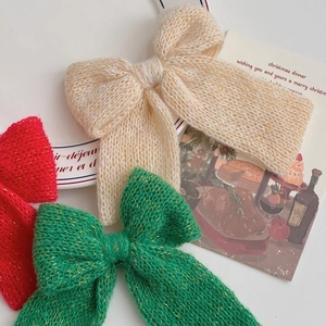 Close-up of handmade knit Christmas bows with gold metallic threads in festive colors