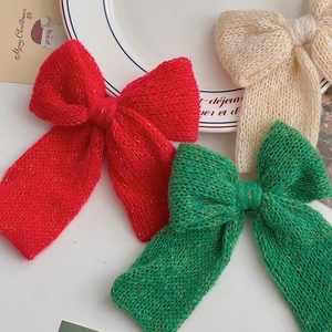 Three-piece set of knitted Christmas bows in red green and white with gold metallic thread