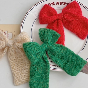 Three-pack knitted Christmas bows in red green and cream with metallic gold accents
