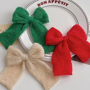 Knitted Christmas bow decorations with gold lurex thread in green, red, and beige colors