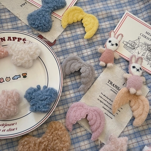 Close-up of fluffy plush angel wings, rabbits and cloud shapes for DIY Christmas crafts