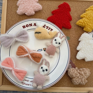 Macro detail of plush Christmas DIY accessories including fluffy stars, bows and trees