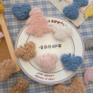 Close-up of DIY plush Christmas accessories in bear and tree shapes on a ceramic plate