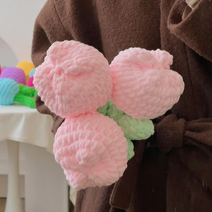 Nahaufnahme von rosa handgehäkelten Tulpen mit feiner Stricktextur und weichem Garnfinish